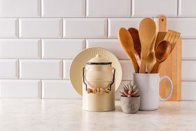 Stylish kitchen background in light colors with stylish kitchen utensils in a minimalist style. Front view. A copy of the space. White brick wall.