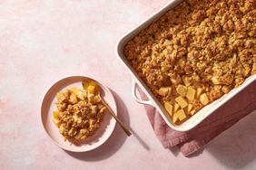 portion of apple crisp on plate and baking dish of apple crisp