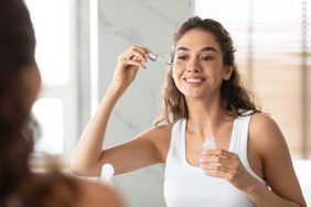 woman applying serum to face