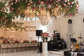 wedding chandelier with roses and greenery wood beams