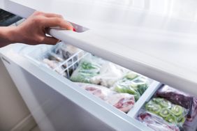 Woman hand opening a refrigerator door