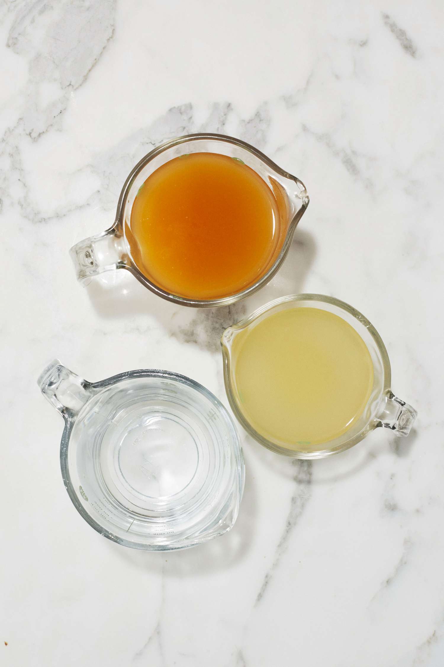 measuring cups of chicken vegetable broth and water