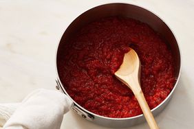 Red sauce in a pot with wooden spoon