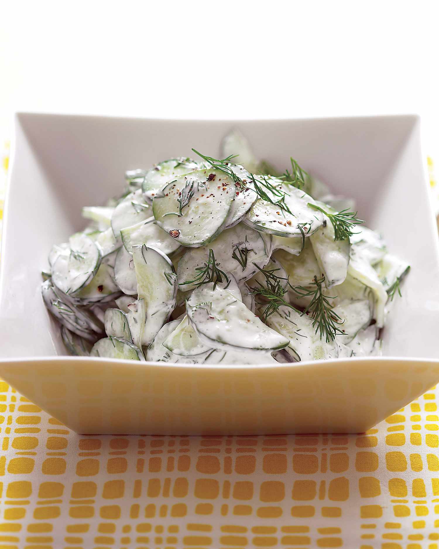 cucumber salad with sour cream and dill dressing in bowl