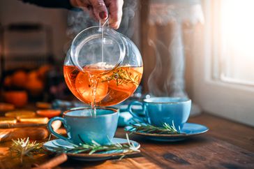 Pouring hot tea into mug