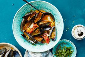 drunken mussels with chorizo and white beans topped with parsley leaves