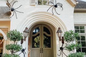 fall porch with large spiders hay and pumpkins