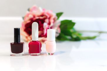 Group of nail polishes of different colors displayed on a marble countertop