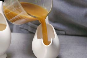 pouring gravy from measuring cup into serving bowl