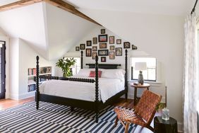 master bedroom with black spool bed and sloped ceilings