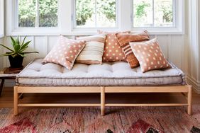 Daybed with throw pillows underneath a window