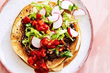 overhead view of a tostada on a pink surface