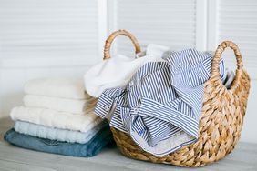 Laundry basket with clothes and pile of laundry