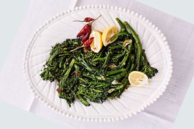 Pepperoncini broccolini with lemon on a white platter