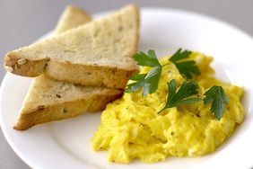 scrambled eggs and toast on a white plate