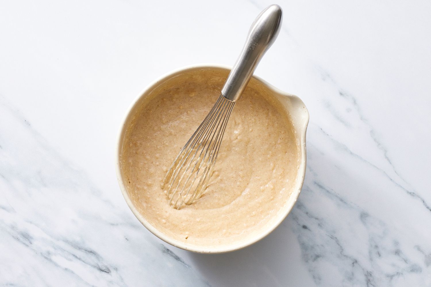 Vegan pancakes batter in bowl with whisk