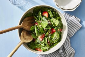 Strawberry Spinach Salad on blue surface with dishtowel 