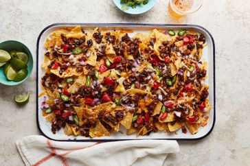 Nachos on a sheet pan with beer, lime