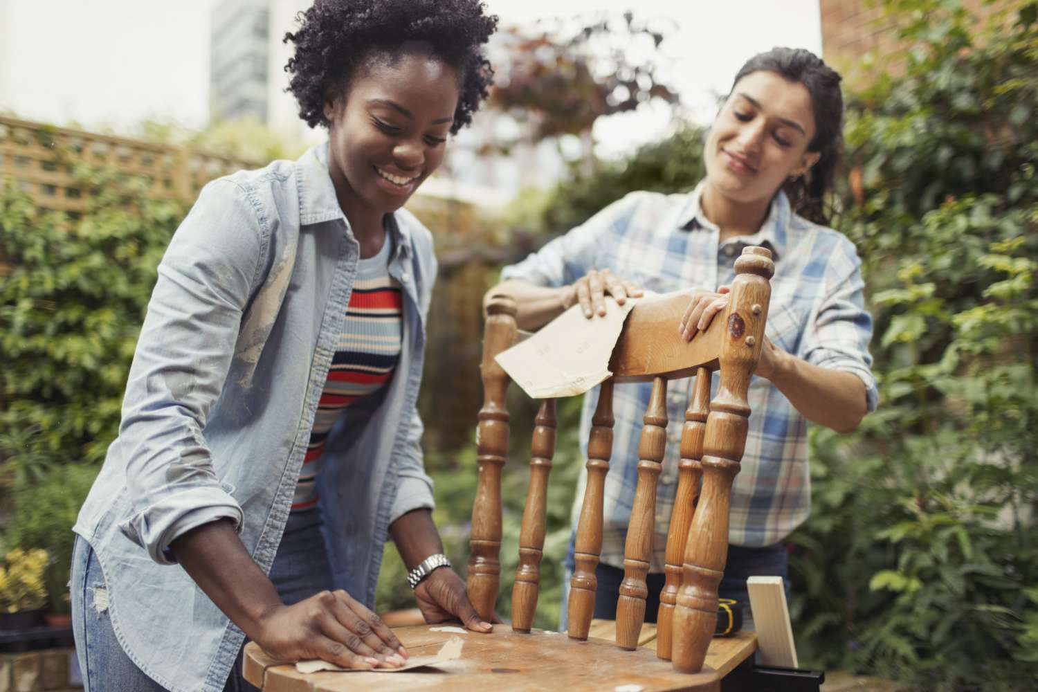 Women friends sanding chair