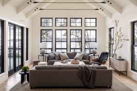 neutral-colored living room with windows overlooking lake