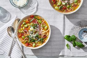 pasta and bean soup served on a table with a gray table cloth