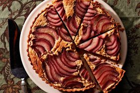 poached-pear frangipane tart on decorative green table cloth