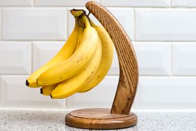 Ripe bananas hanging on wooden hanger