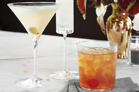 close up of 3 cocktails and a floral arrangement