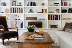 white wall of shelving wooden coffee table sofa and chair