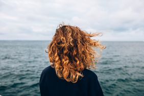 woman with curly hair looking at waterfront